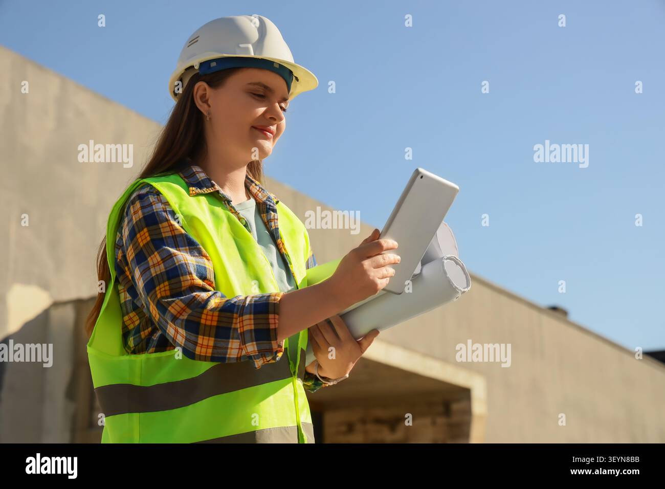 Female construction worker using tablet at building site Stock Photo
