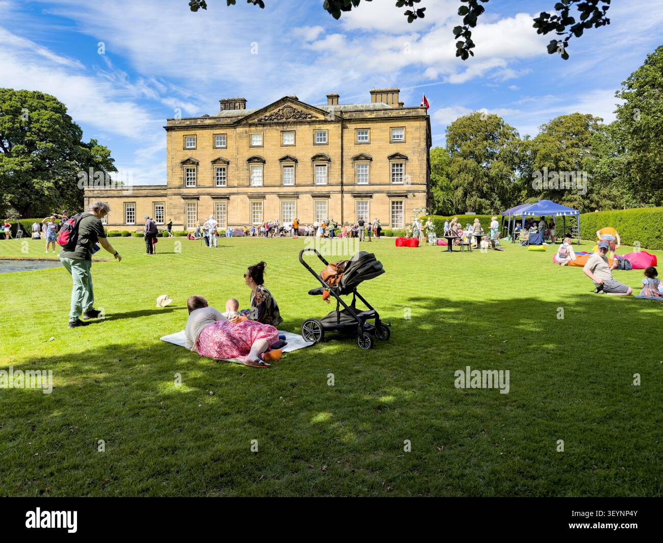 Visitors relaxing on the lawn at Blagdon Hall open day northumberland - Smartphone Captured Stock Image