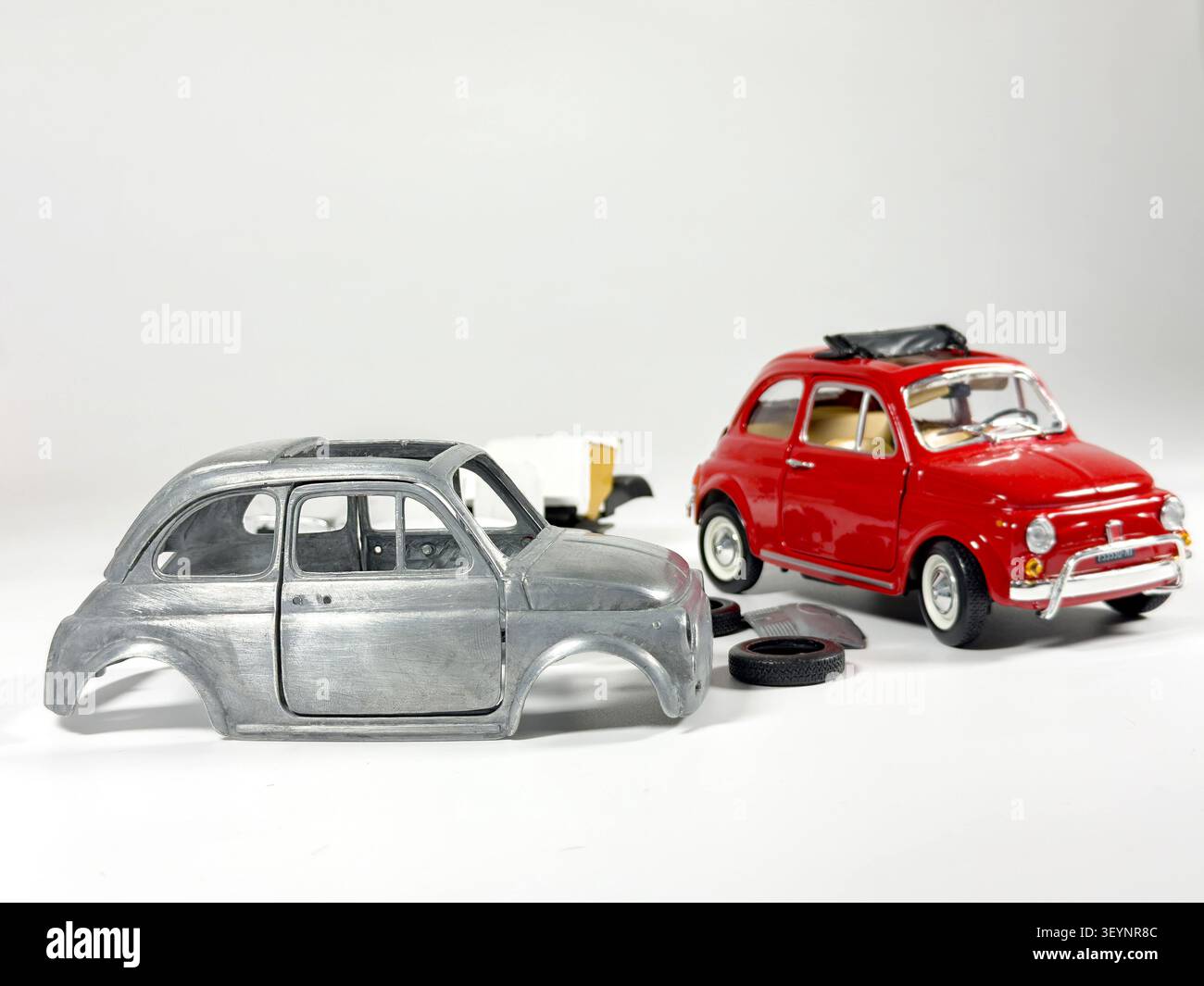 Miniature fiat 500 replica & model car assembly concept on white studio background - Smartphone Captured Stock Image