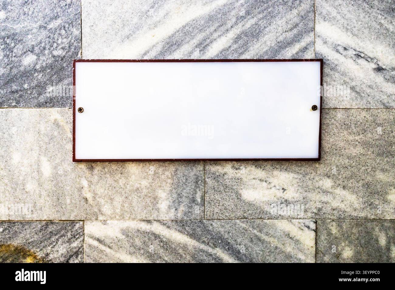 blank white sign on wall made of marble slabs Stock Photo