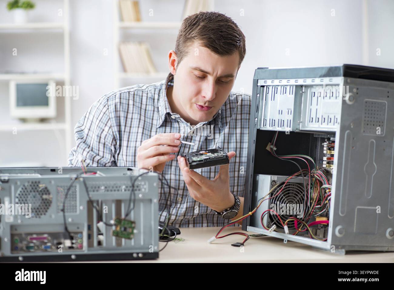 Young technician repairing computer in workshop Stock Photo
