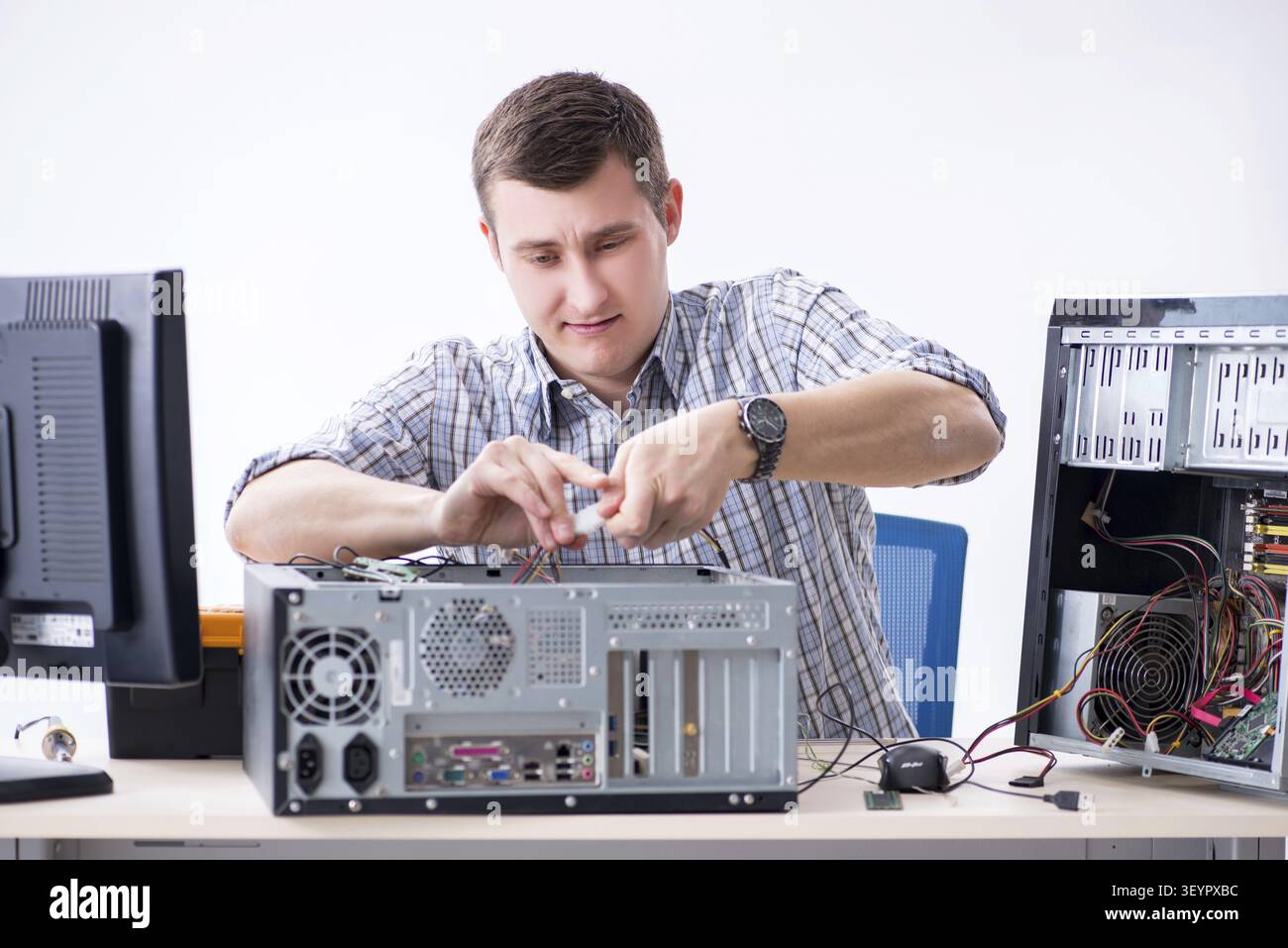 Young technician repairing computer in workshop Stock Photo
