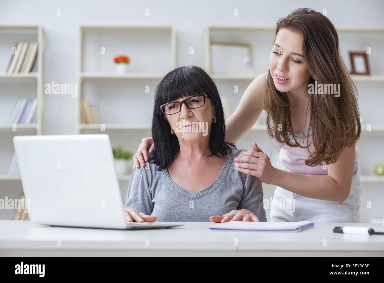 Daughter explaining to mom how to use computer Stock Photo
