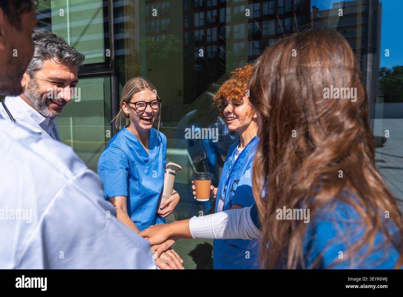 Medical team collaborating and stacking hands outdoors Stock Photo