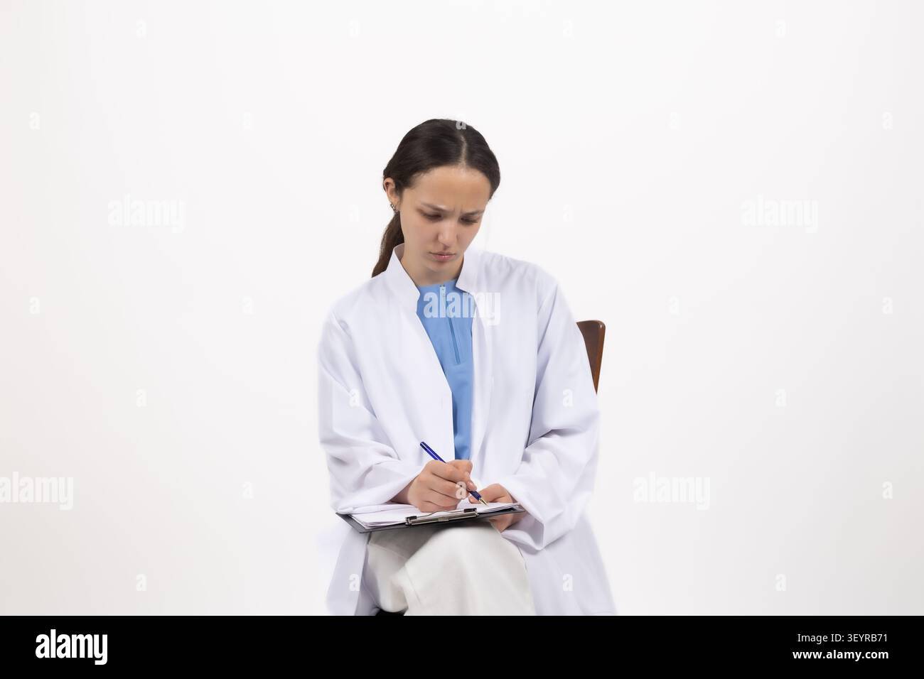 Female scientist taking notes in laboratory journal in a professional photo s... Stock Photo