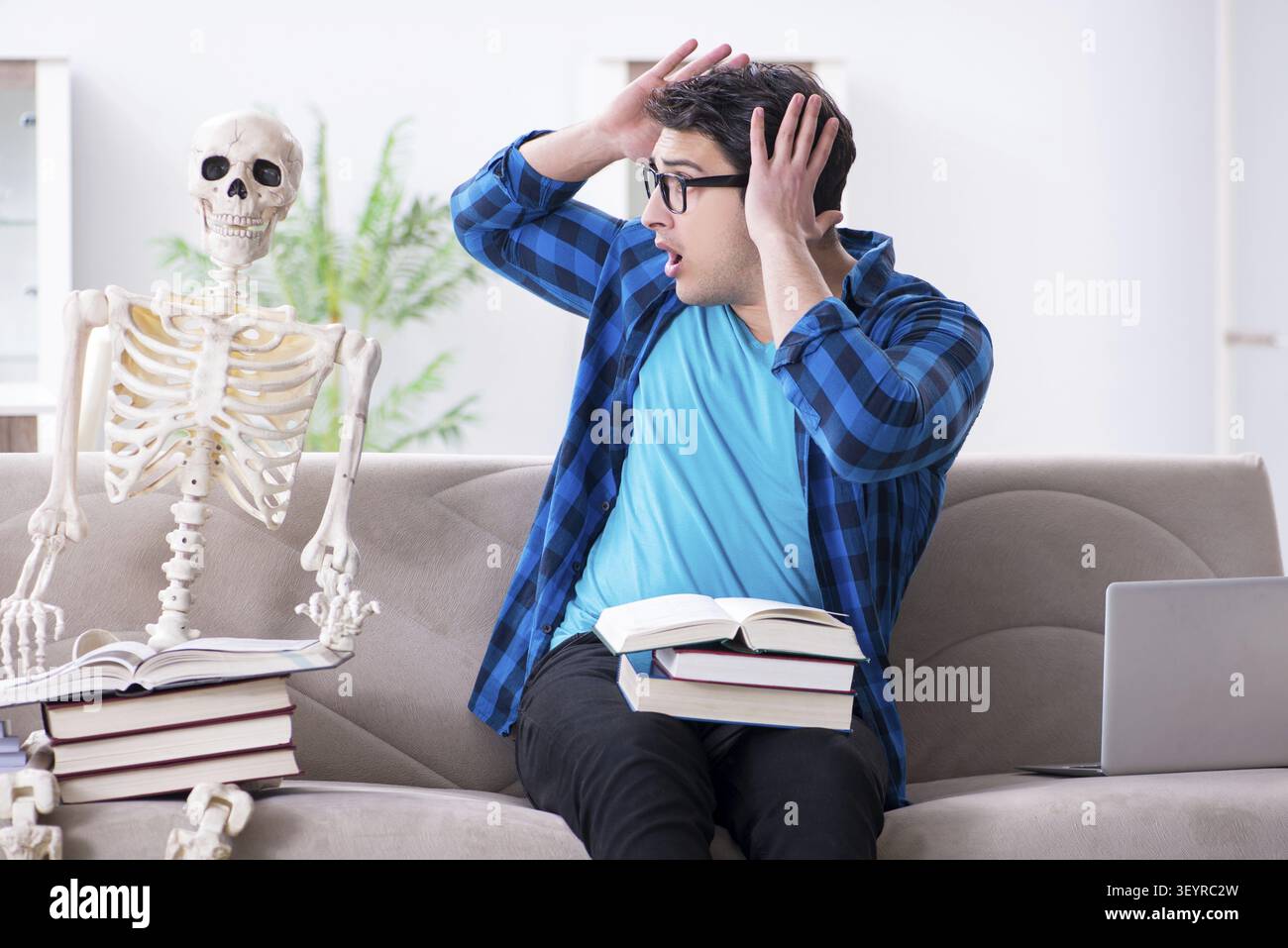 Student studying with skeleton preparing for exams Stock Photo