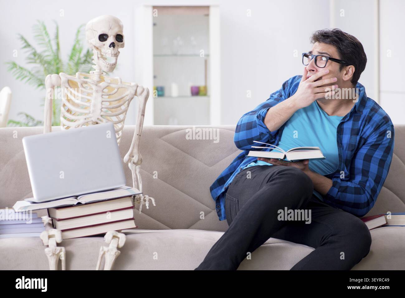 Student studying with skeleton preparing for exams Stock Photo