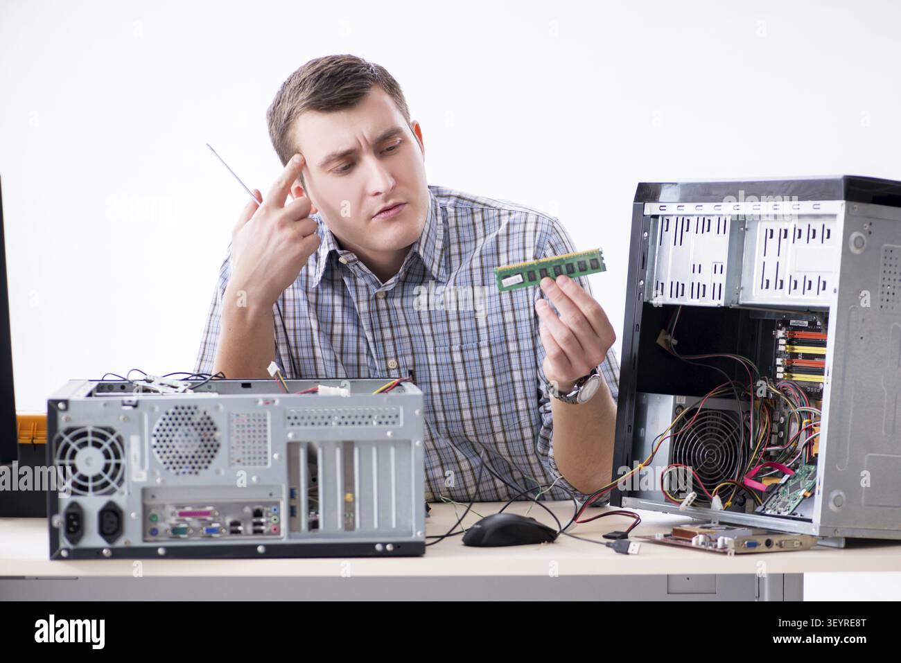 Young technician repairing computer in workshop Stock Photo