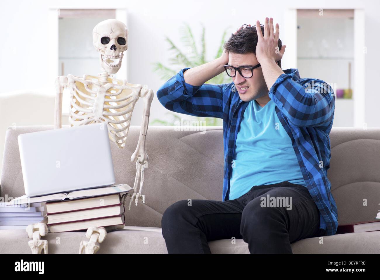 Student studying with skeleton preparing for exams Stock Photo