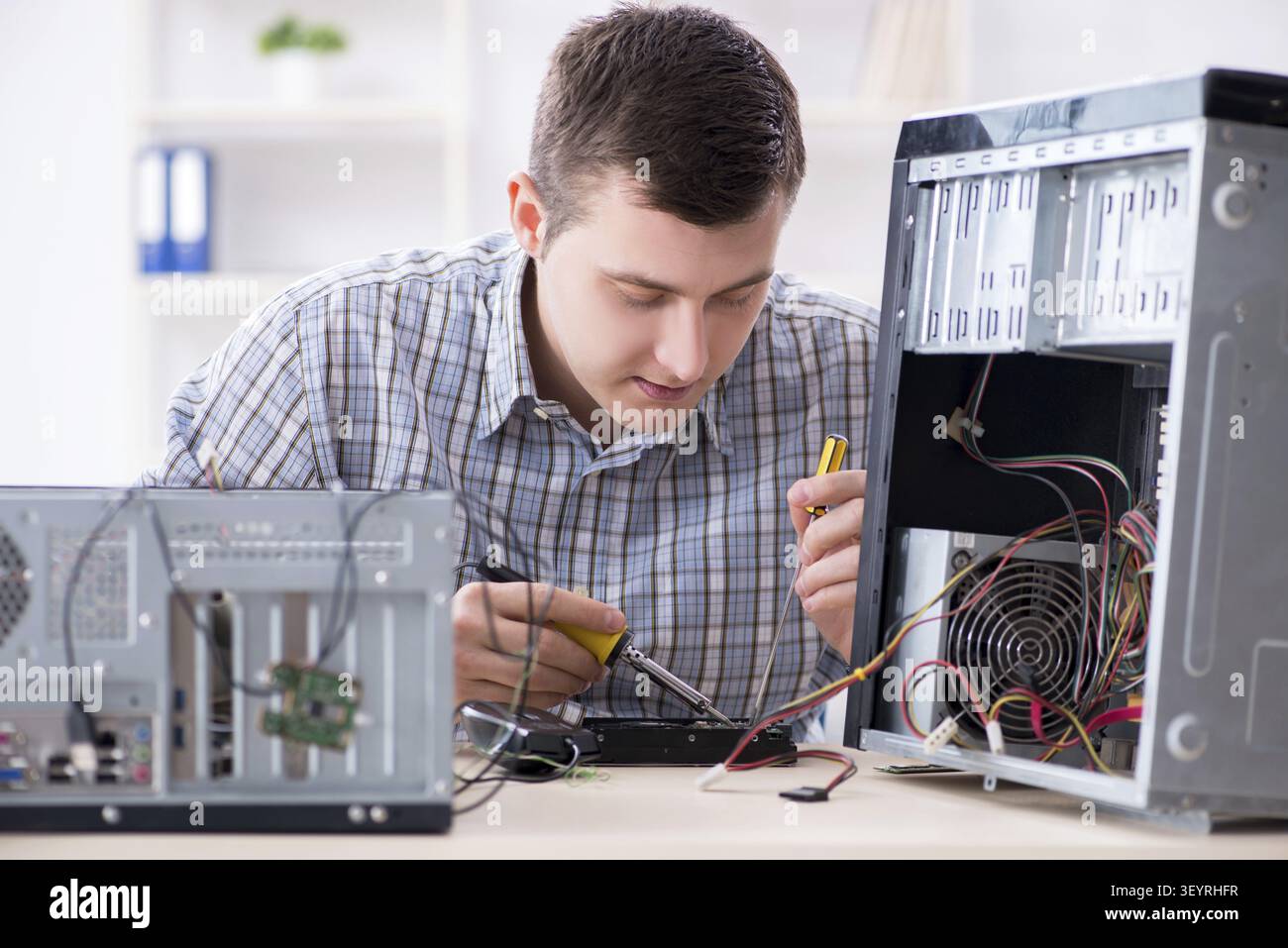 Young technician repairing computer in workshop Stock Photo