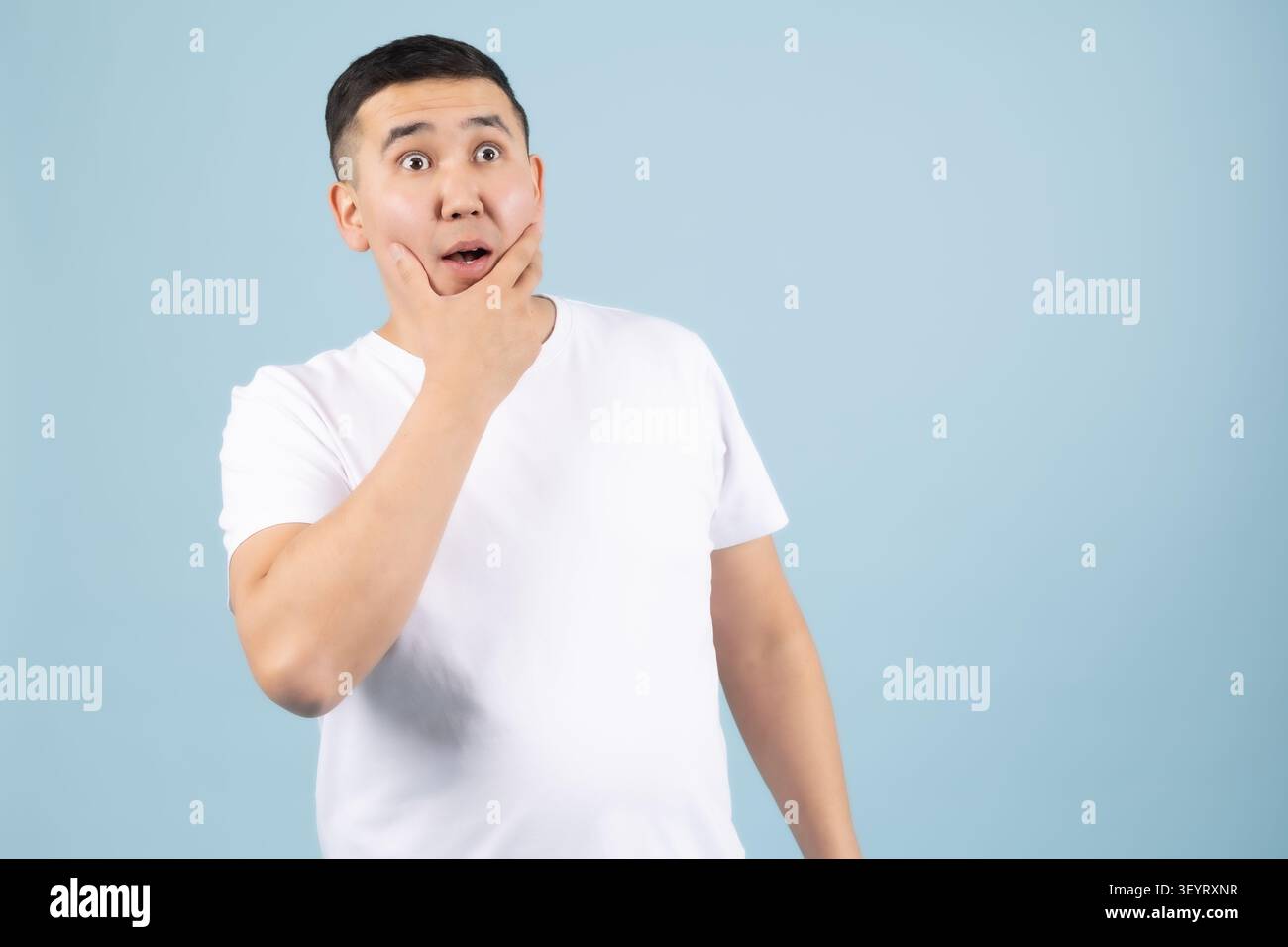 Young man touching his chin with a thoughtful expression on face Stock Photo