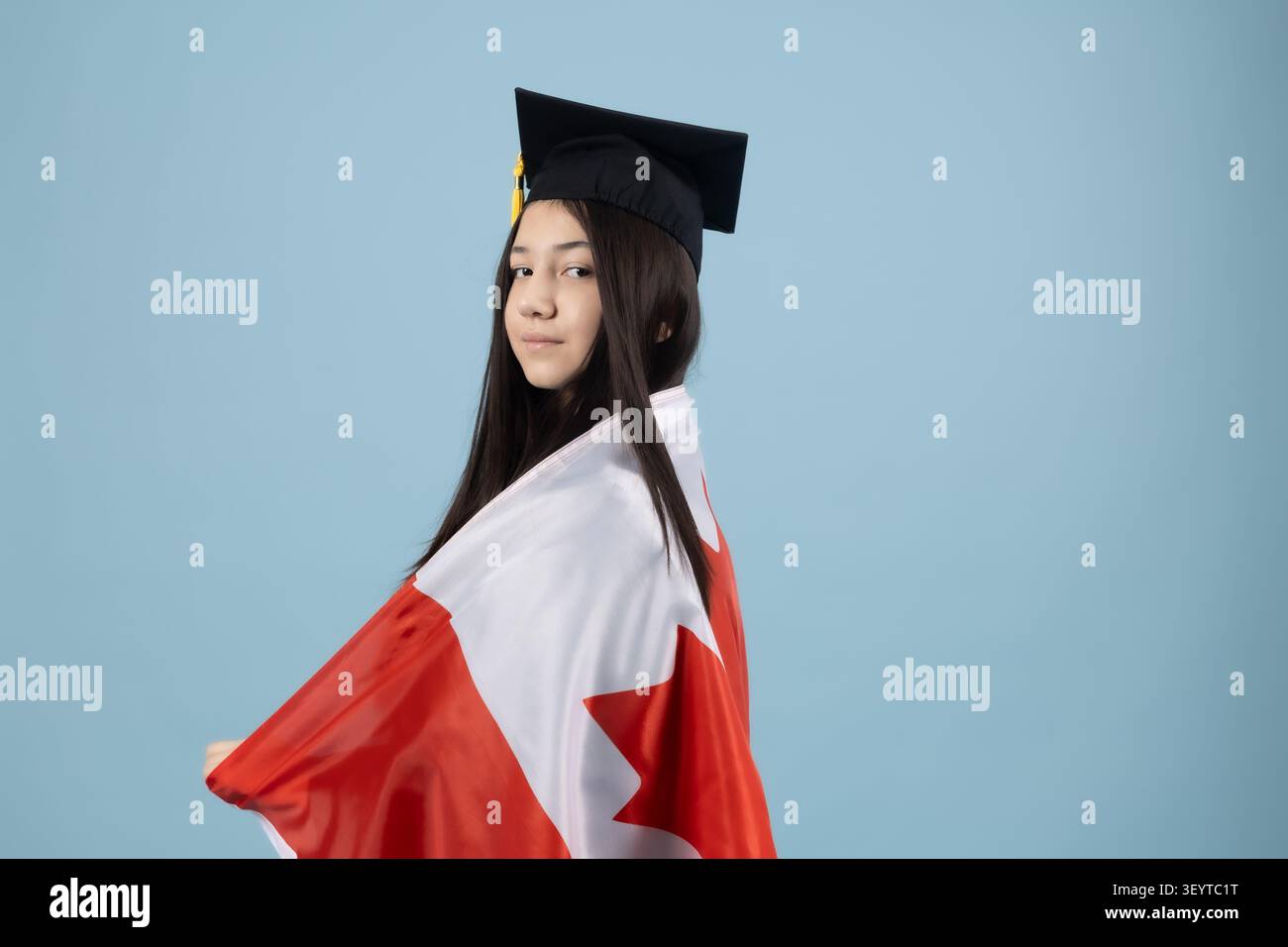Proud graduate student holding a national flag to celebrate degree Stock Photo