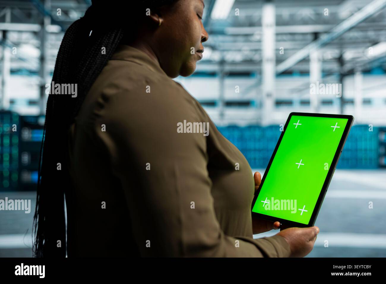 Data center engineer works with a chroma key tablet, using an editable screen to review performance data. Stock Photo