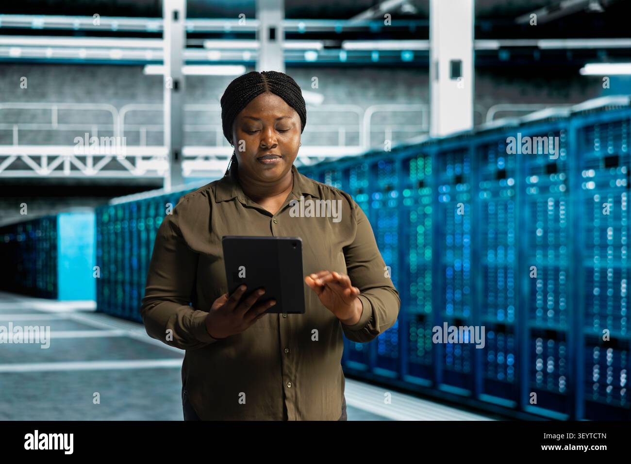 Data center engineer uses a desktop computer in a data center to support failure detection and reliable server workflows. Stock Photo