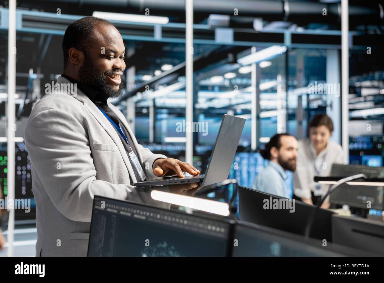 Pleased data center administrator celebrates a successful server software update in a data center. Stock Photo