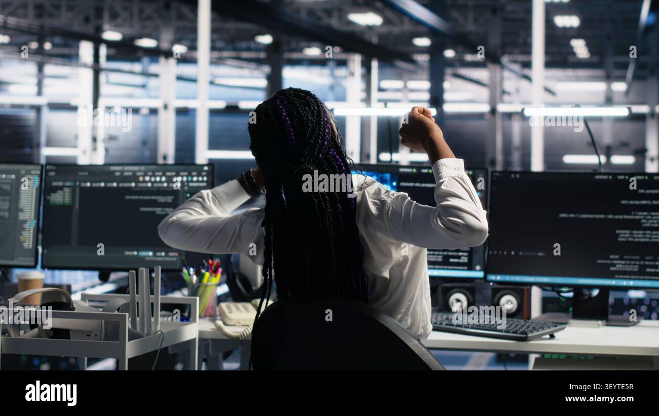 Server room manager checking work done by admins working with deep learning to review data sets. Stock Photo