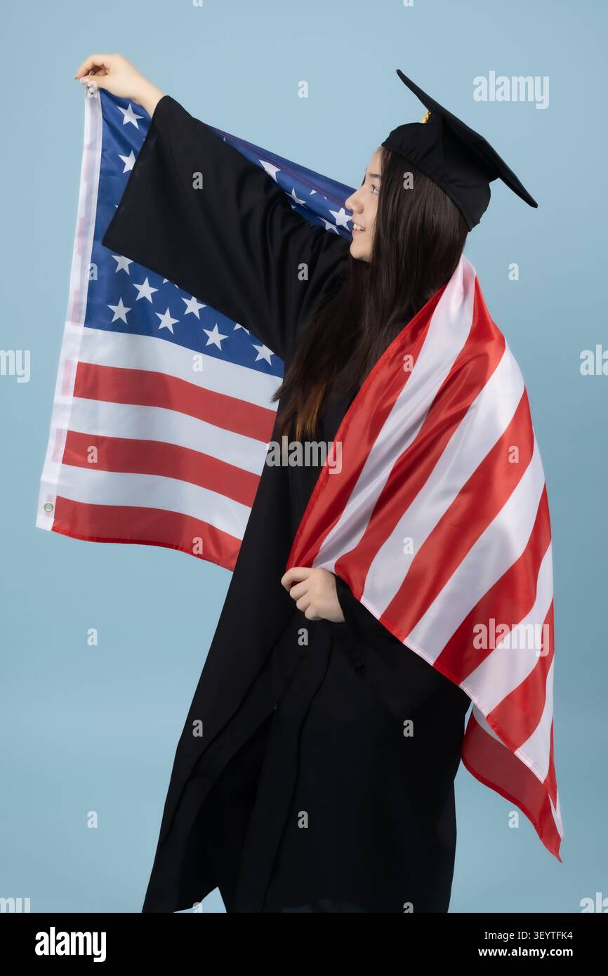 Proud graduate student holding a national flag celebrating degree Stock Photo