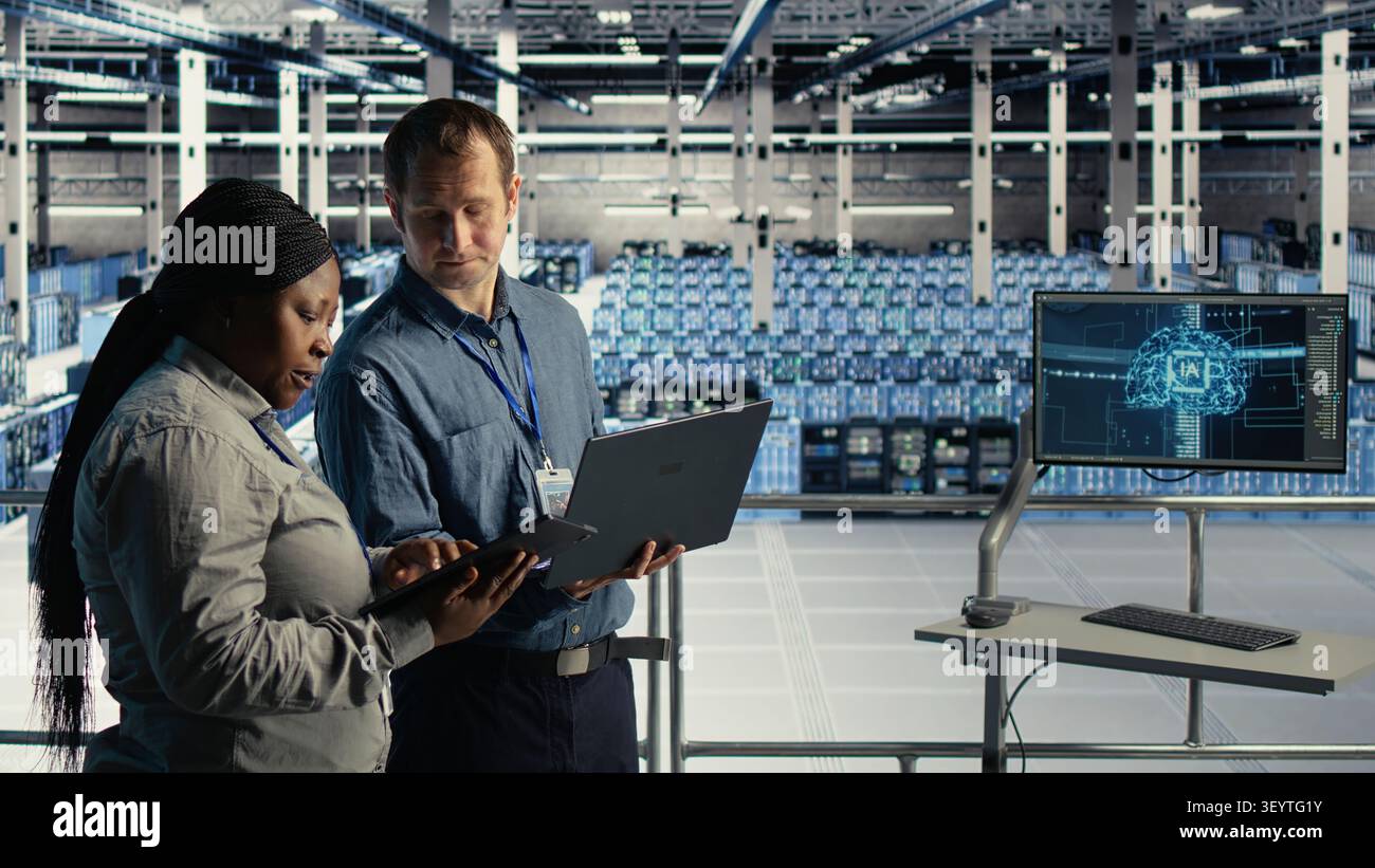 Data center engineering team manages software updates in a server room to keep data center systems stable. Stock Photo