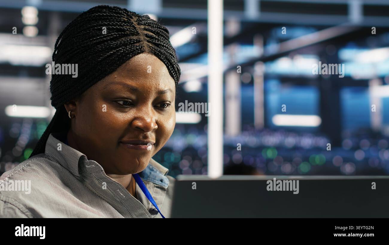 System administrator works through node tree software problems while analyzing AI infrastructure in a data center. Stock Photo