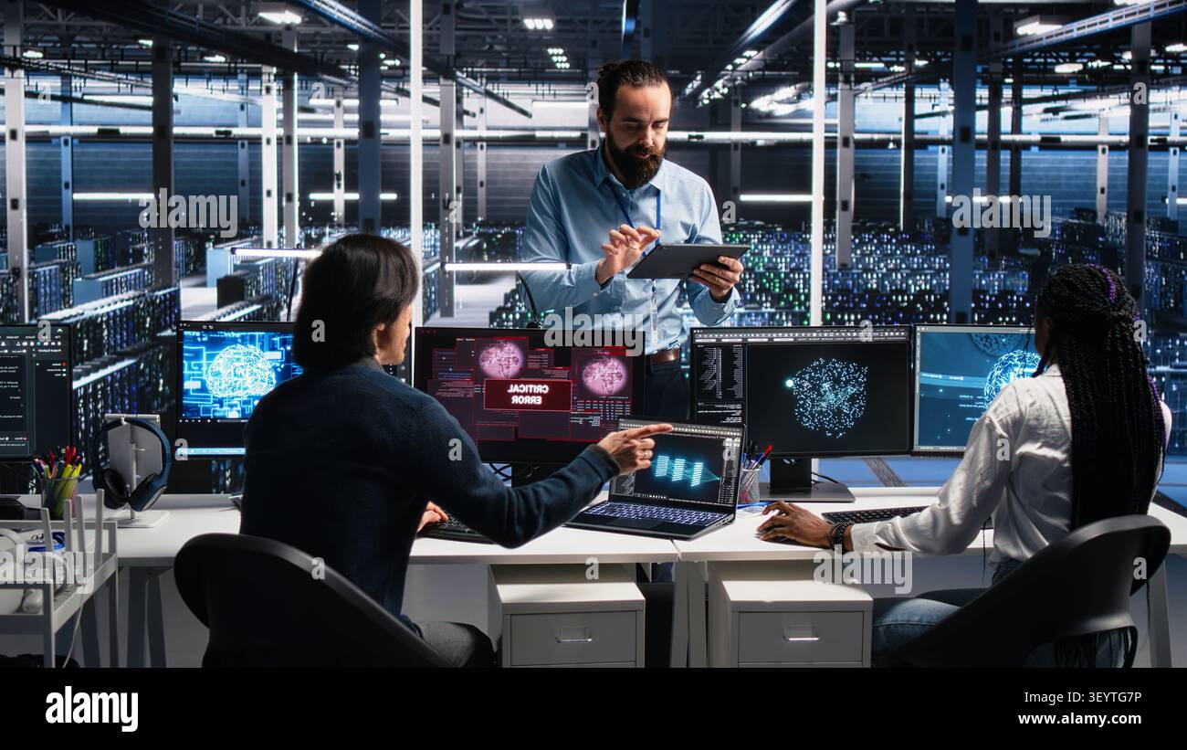 System administrators in server room struggle with computer bugs while working with AI. Stock Photo
