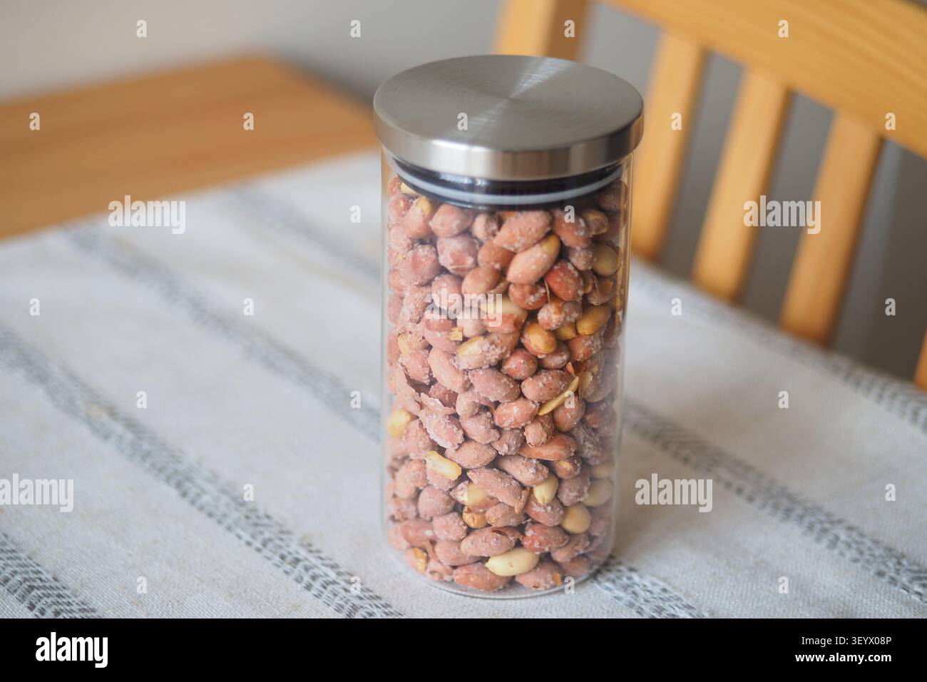 Container holds peanuts on a table in a kitchen Stock Photo