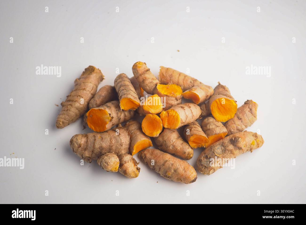 Turmeric root displayed on a plain background Stock Photo