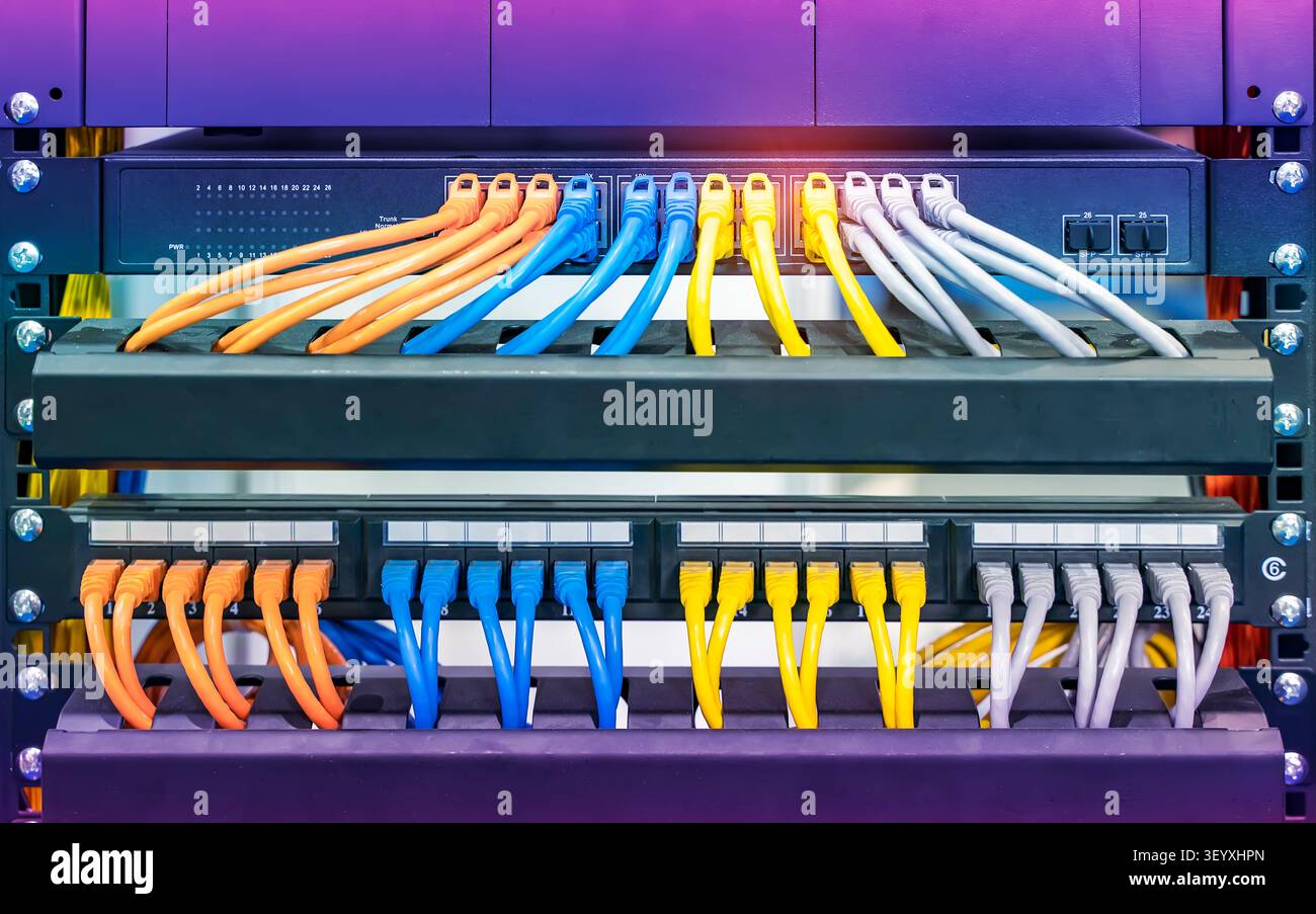 colorful network cables connected on network switches panel in data center Stock Photo