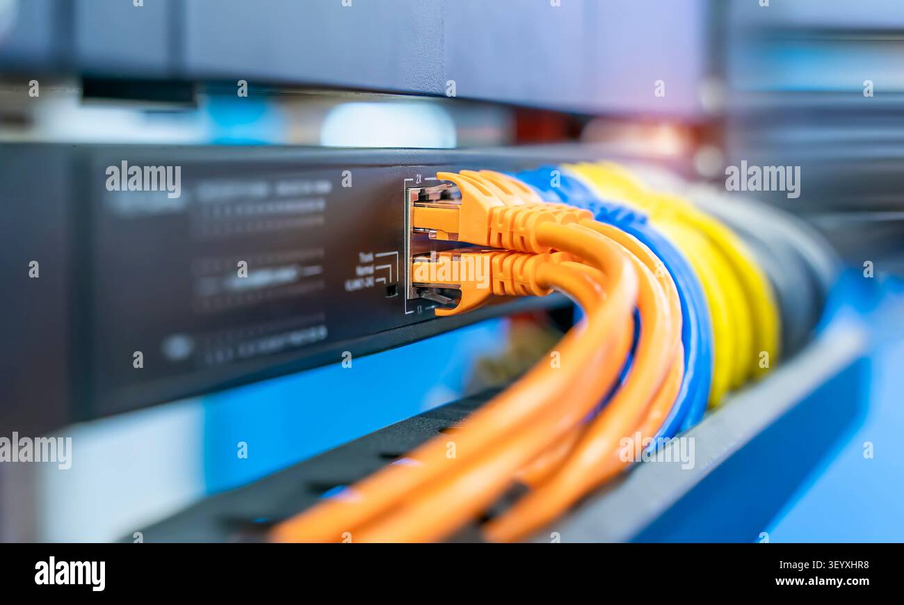 colorful network cables connected on network switches panel in data center Stock Photo