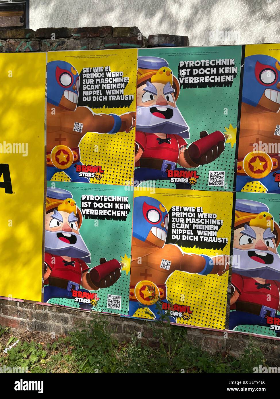 Brightly coloured marketing posters for the mobile video game Brawl Stars pasted onto an outdoor street wall in Berlin, Germany - Smartphone Captured Stock Image
