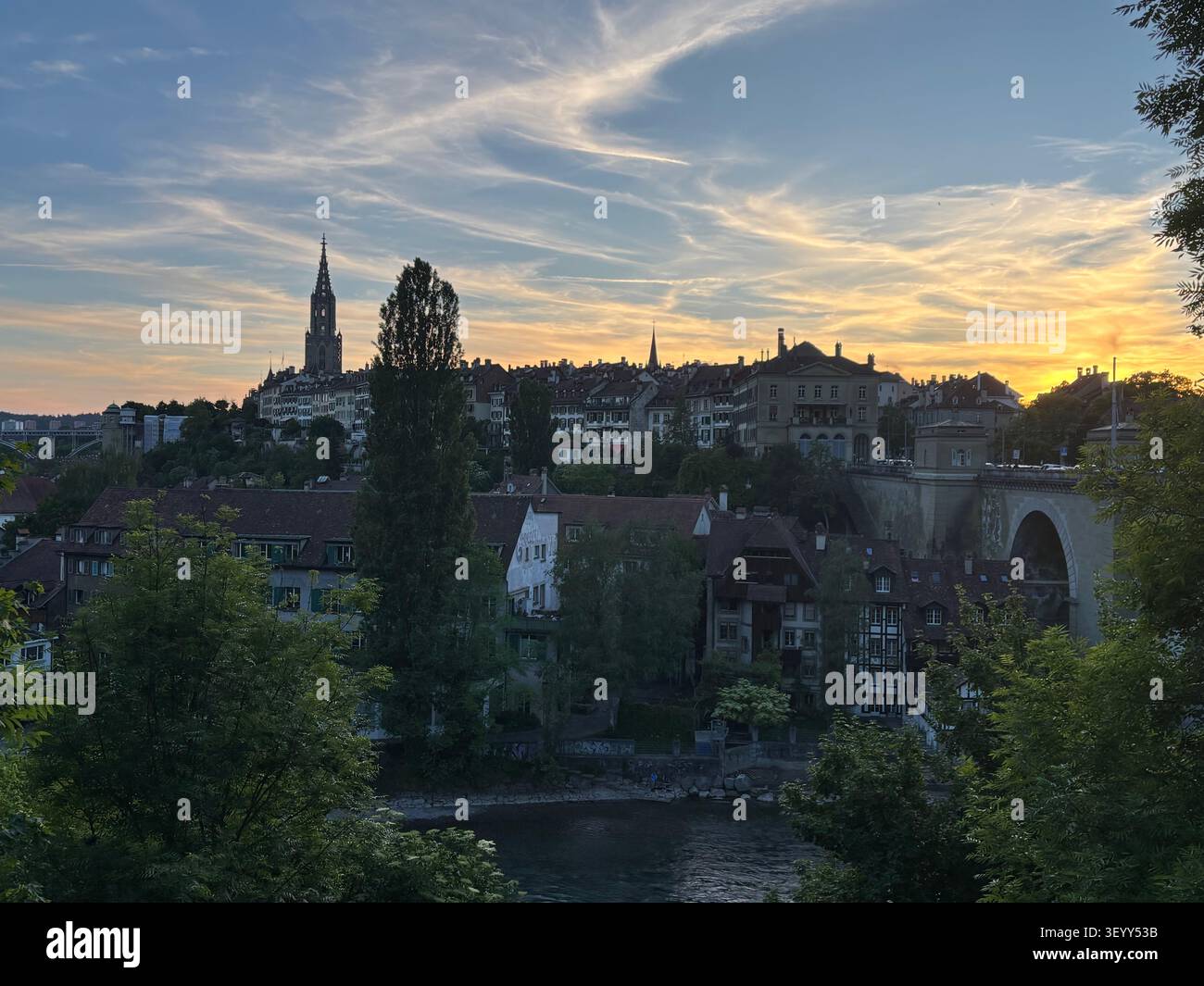 Sunset sky over the historic city of Bern, showing the Nydeggbrücke bridge and cathedral spire, Switzerland - Smartphone Captured Stock Image