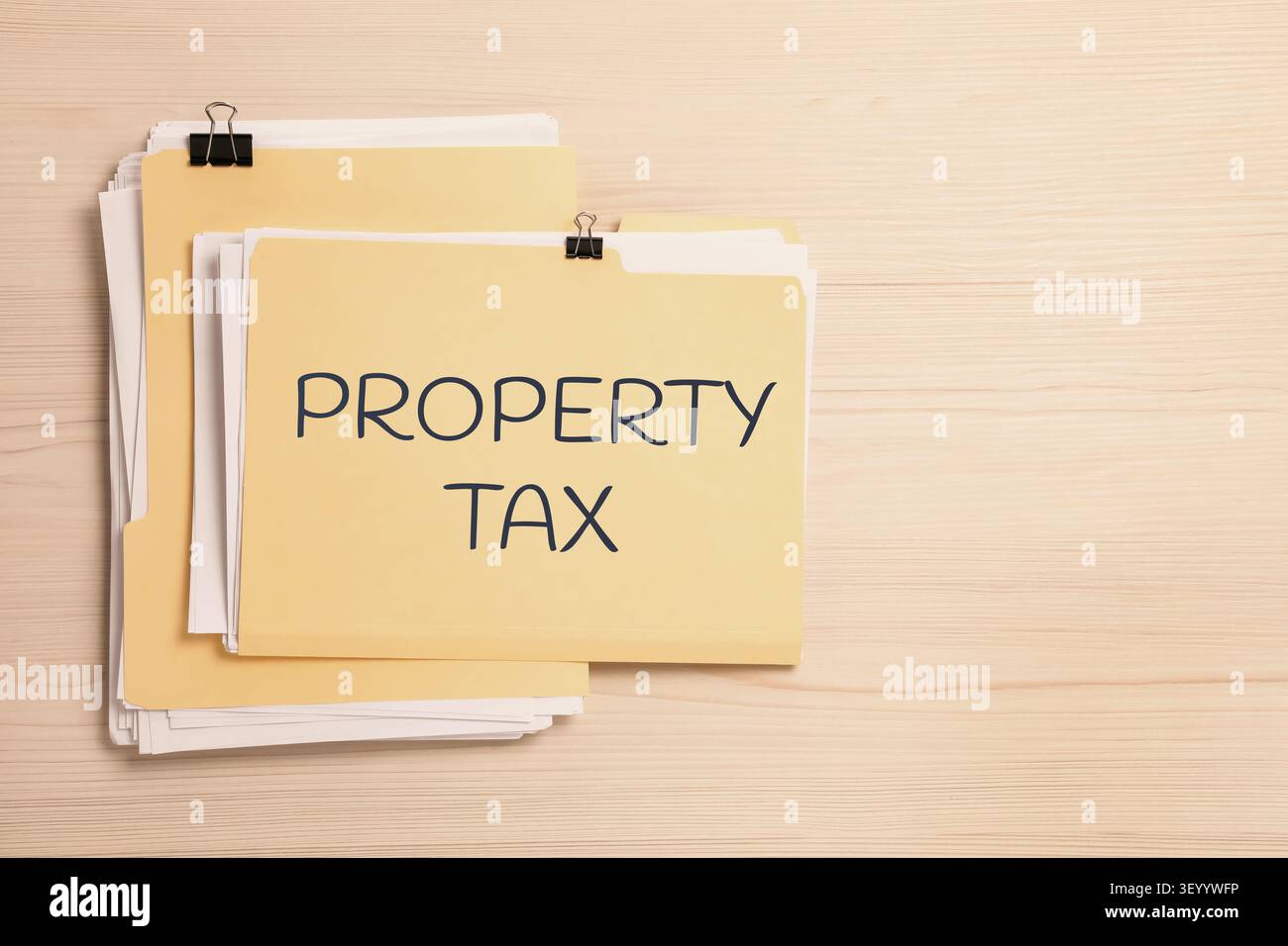 Property tax. Folders with documents on wooden table, top view. Space for text Stock Photo