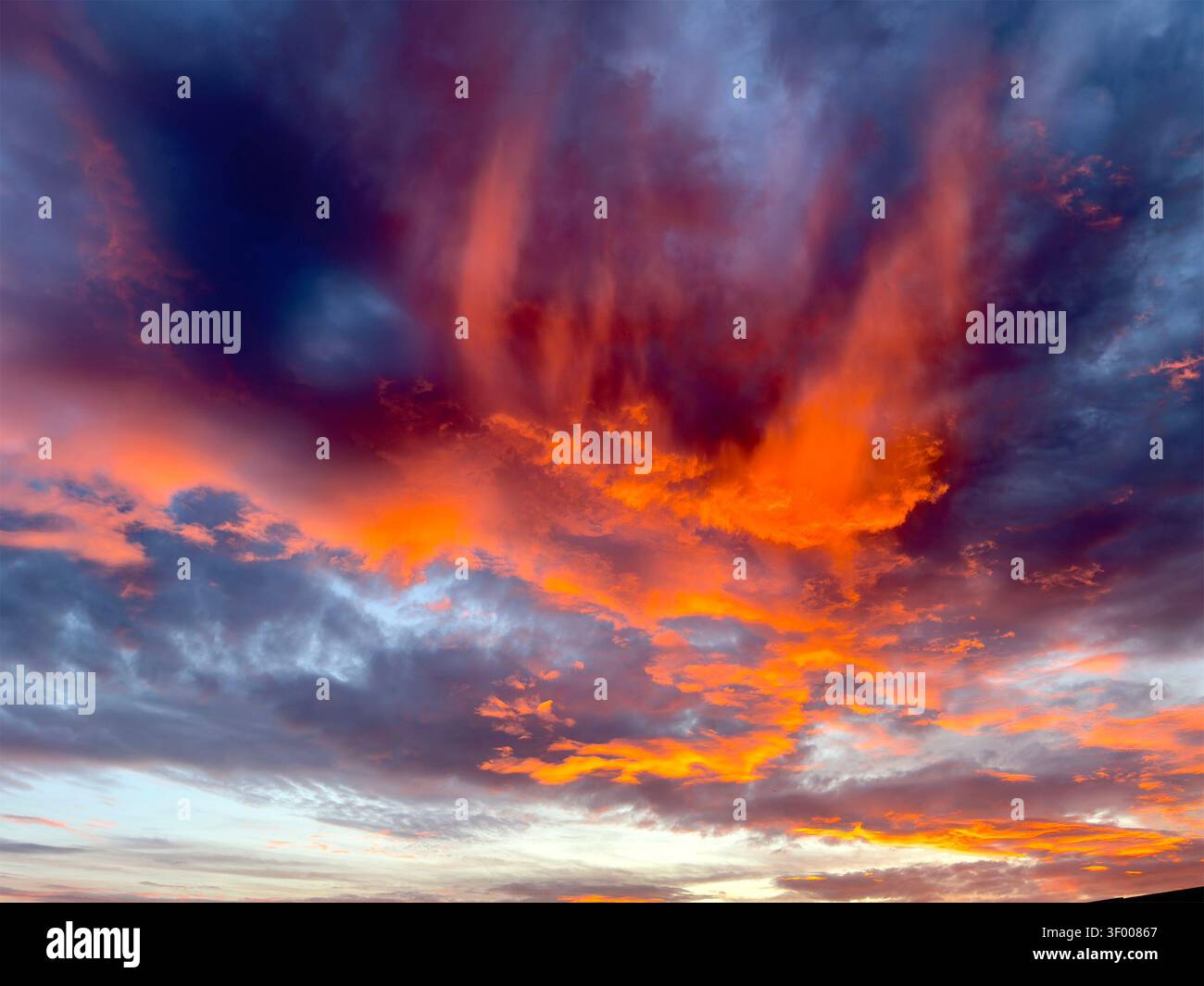 Vibrant orange & blue sky with clouds during sunset Stock Photo