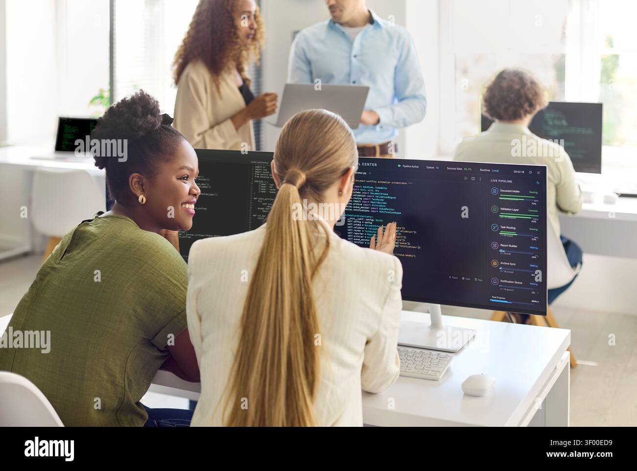 Diverse developers collaborating on code in modern office teamwork and technology Stock Photo