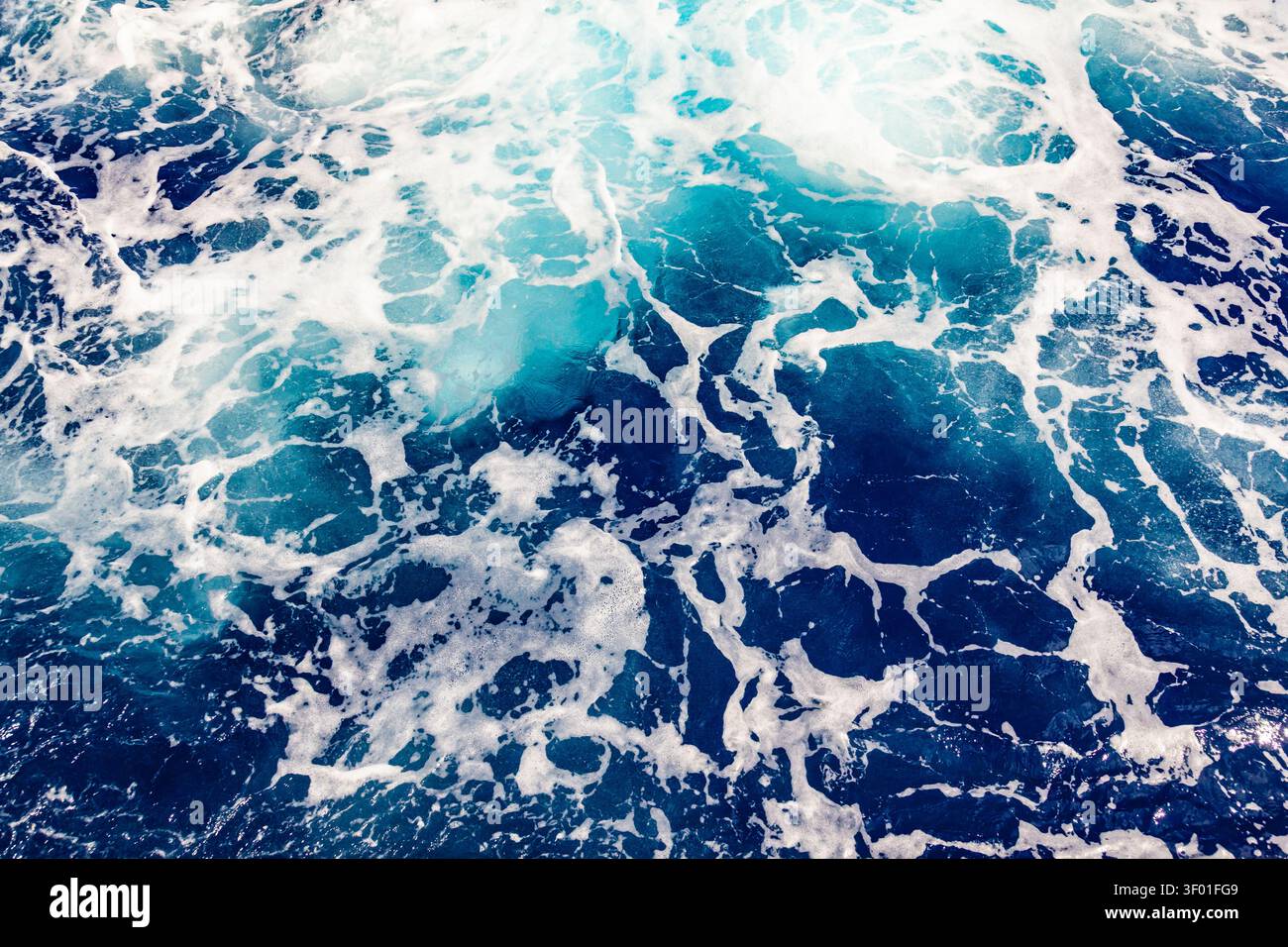 Top down view of deep blue sea water surface with dynamic white foam trail ripples and liquid abstract texture Stock Photo