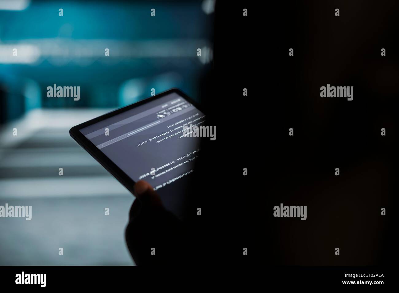 Data center engineer uses a digital tablet in a data center to run hardware diagnostics and maintain operational stability. Stock Photo