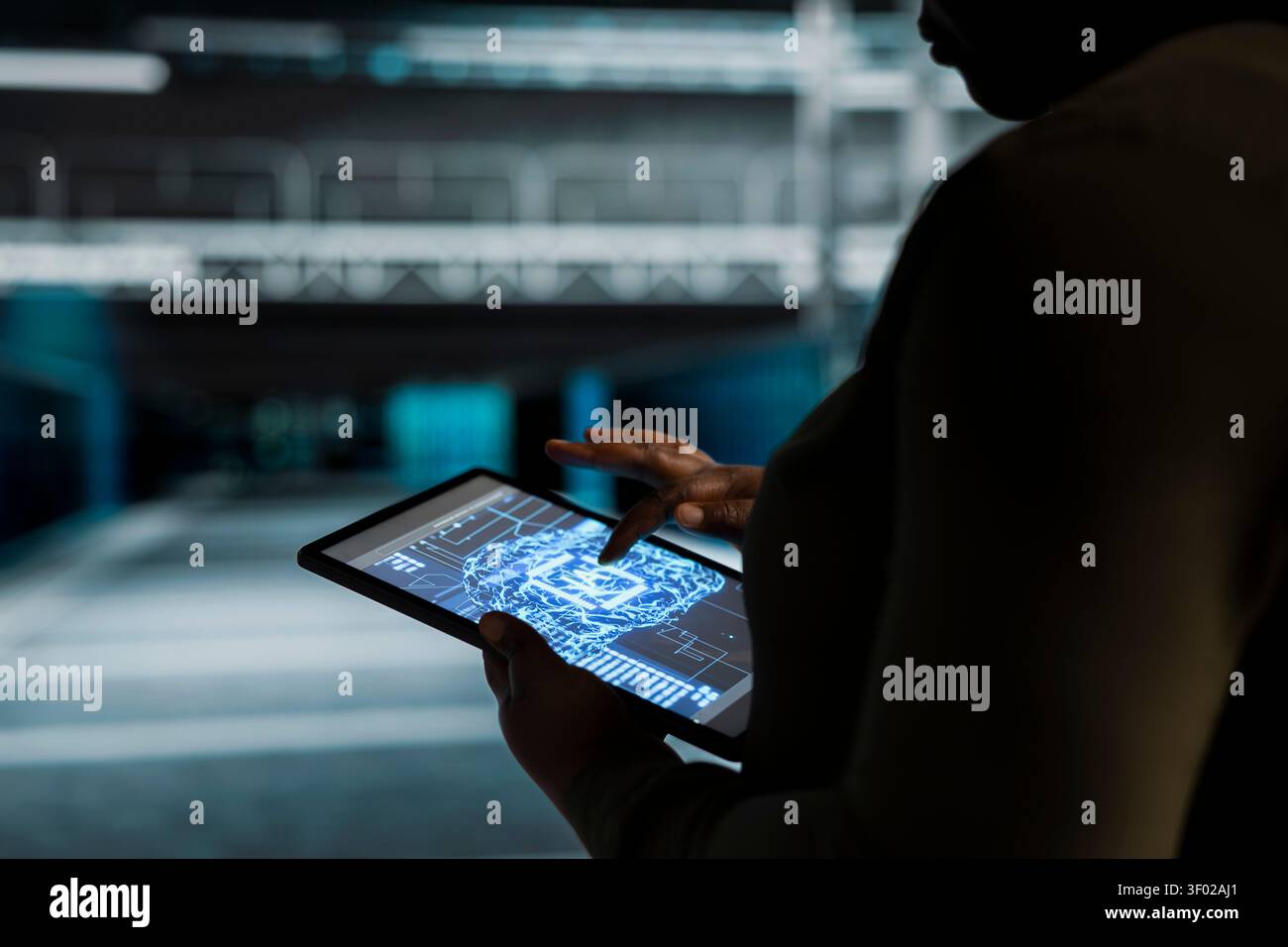 Computer scientist works with a computer workstation in a server hub to support artificial intelligence systems. Stock Photo