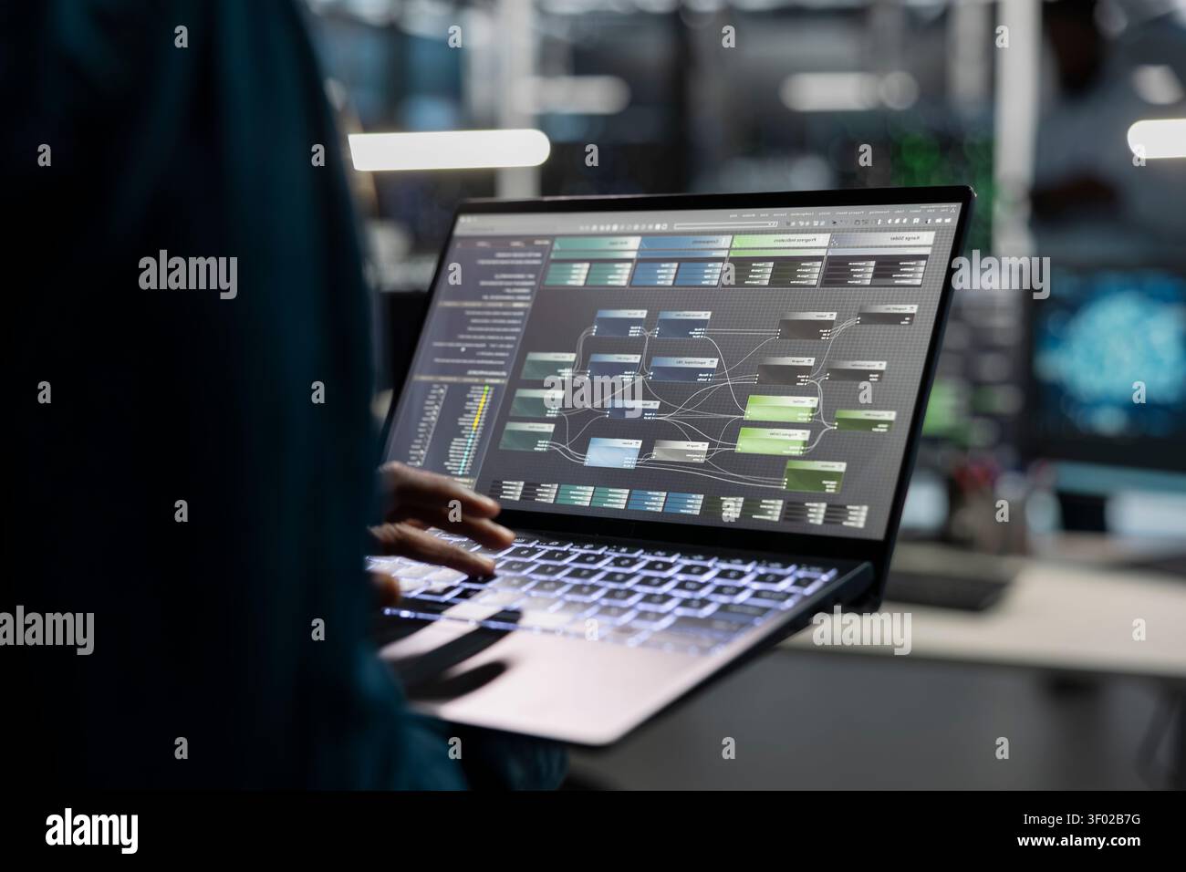 Data center engineer uses a laptop to manage machine learning workloads, working with AI technology and high performance systems. Stock Photo