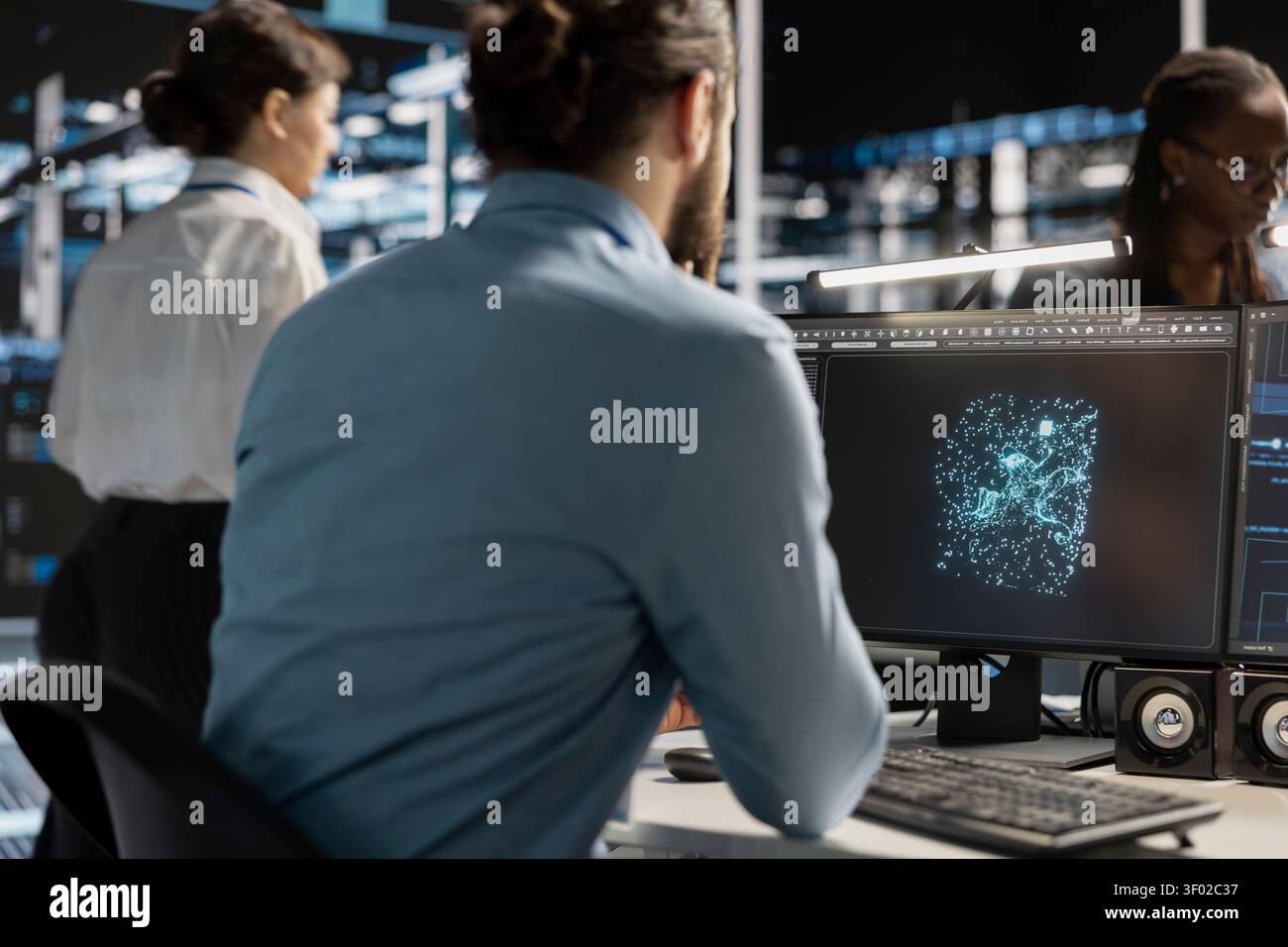 IT specialist uses a desktop computer in a data center to manage AI systems and optimize server infrastructure. Stock Photo