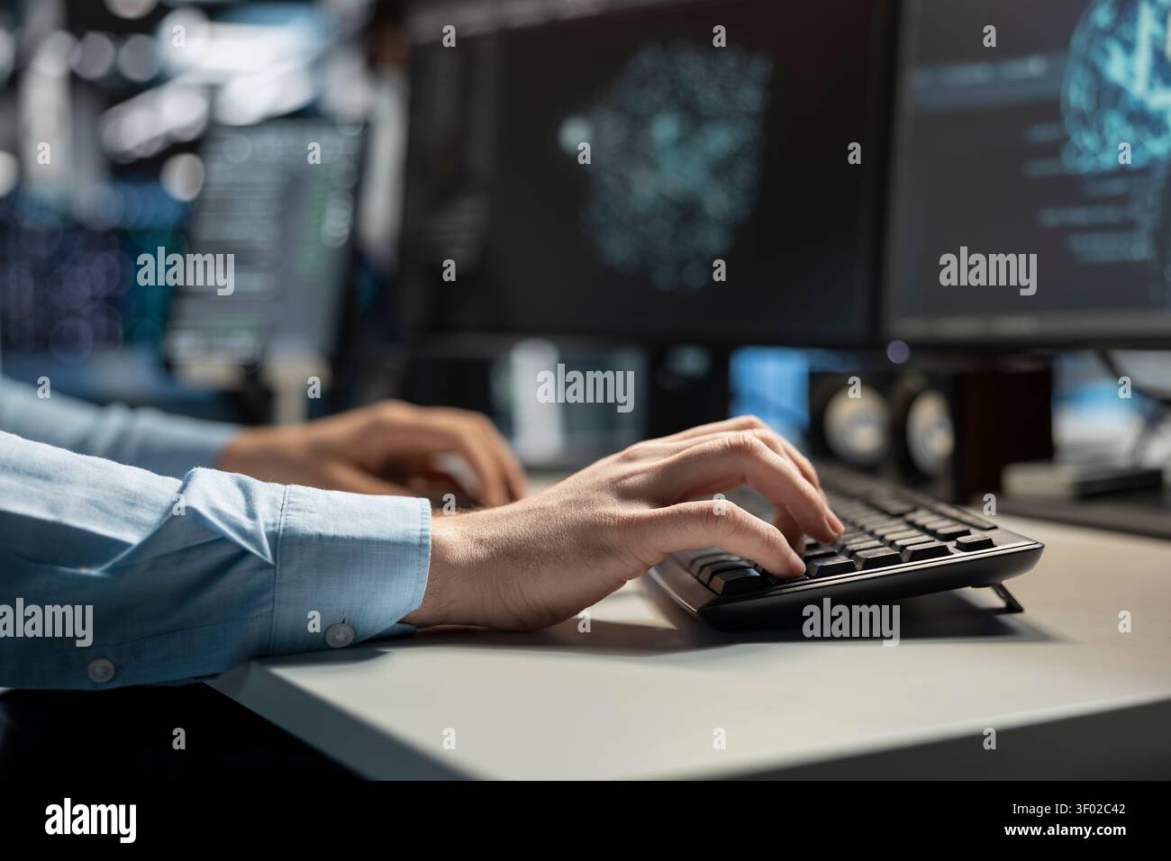 Data center technician uses a desktop computer in a data center to deploy software updates, configure hardware, and support reliable operations. Stock Photo