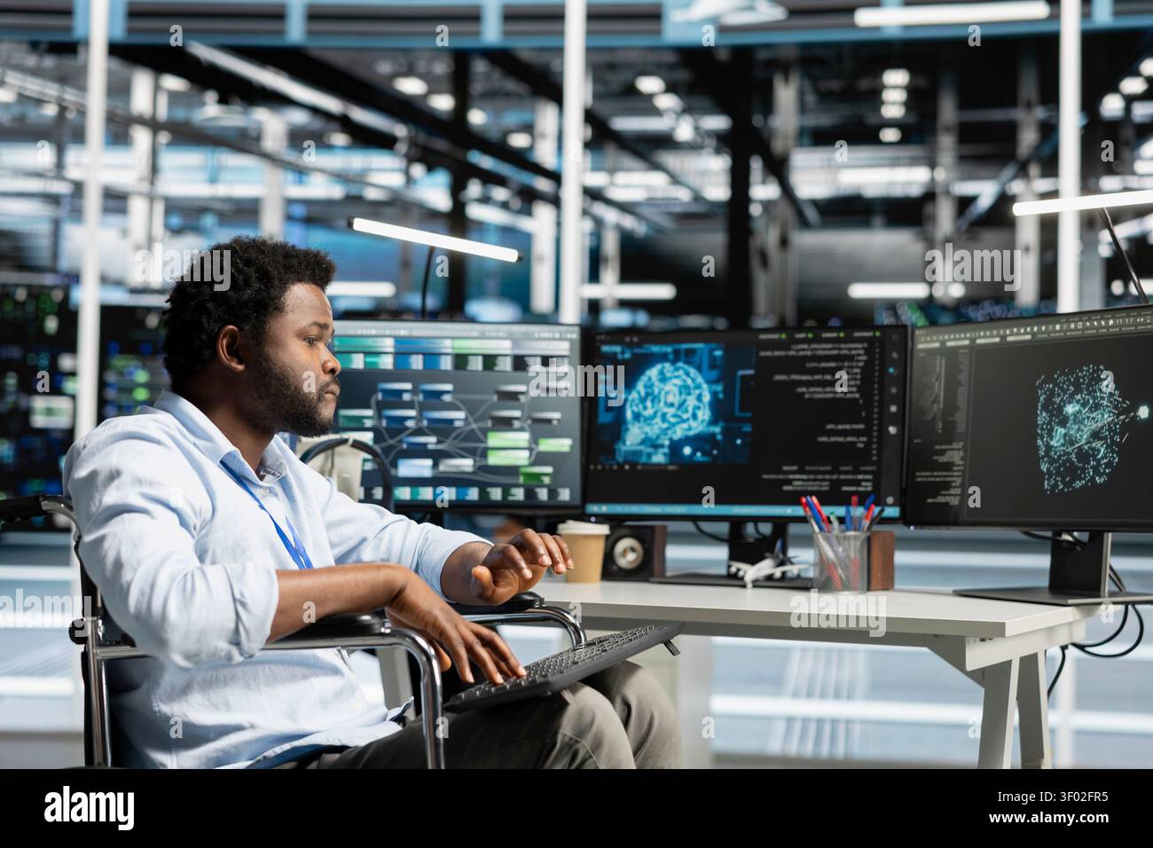 Data center engineer using a wheelchair uses a computer to manage machine learning workloads, working with AI technology and high performance systems. Stock Photo