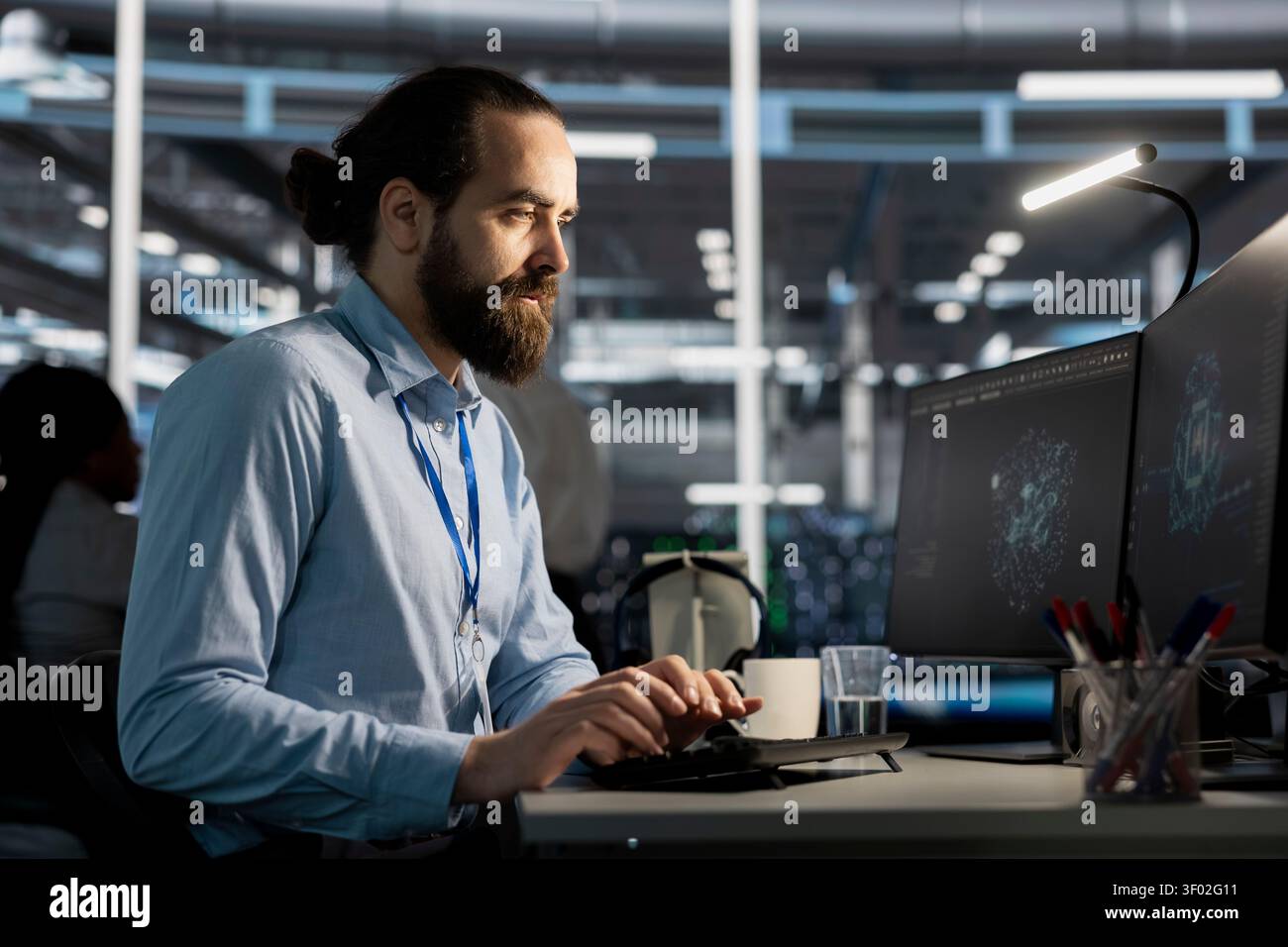Software developer reviews artificial intelligence systems and machine learning processes inside a data center. Stock Photo