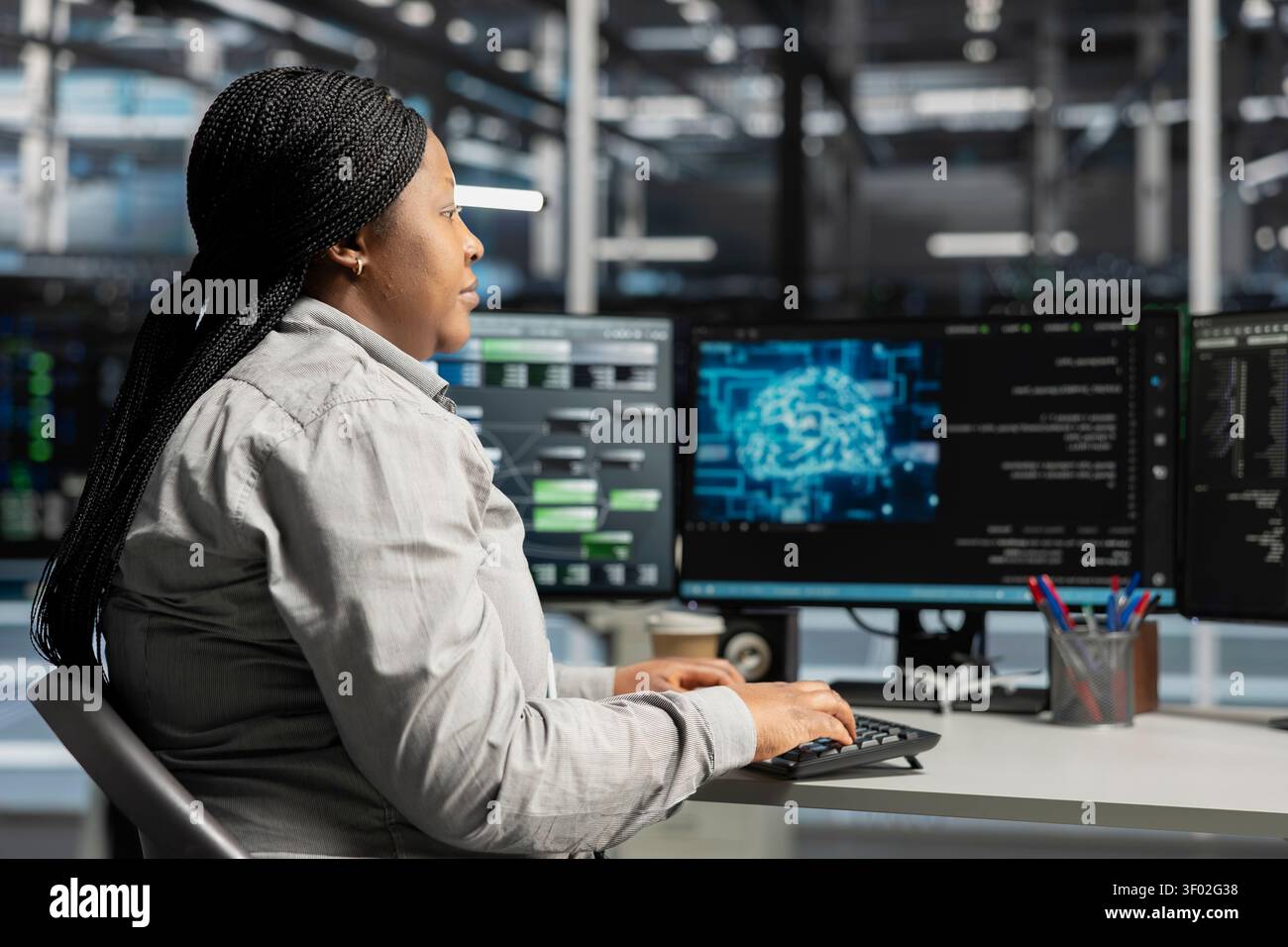 Server facility computing specialist applying AI neural network models technology. Woman working in data center working with AI programming tools on workstation, setting up specialized hardware. Stock Photo