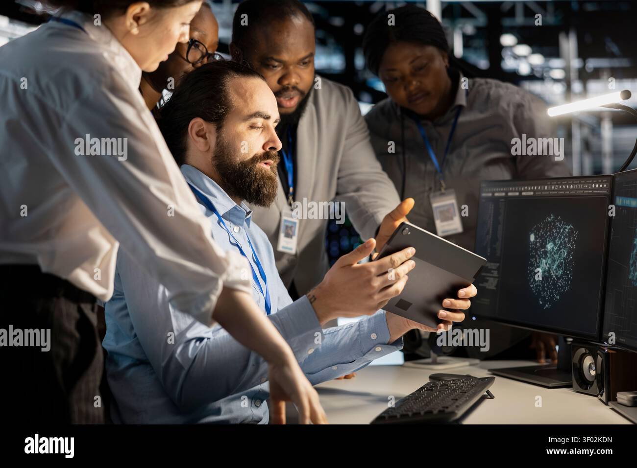 Team of software developers working with workstation in server environment, analyzing data. Stock Photo