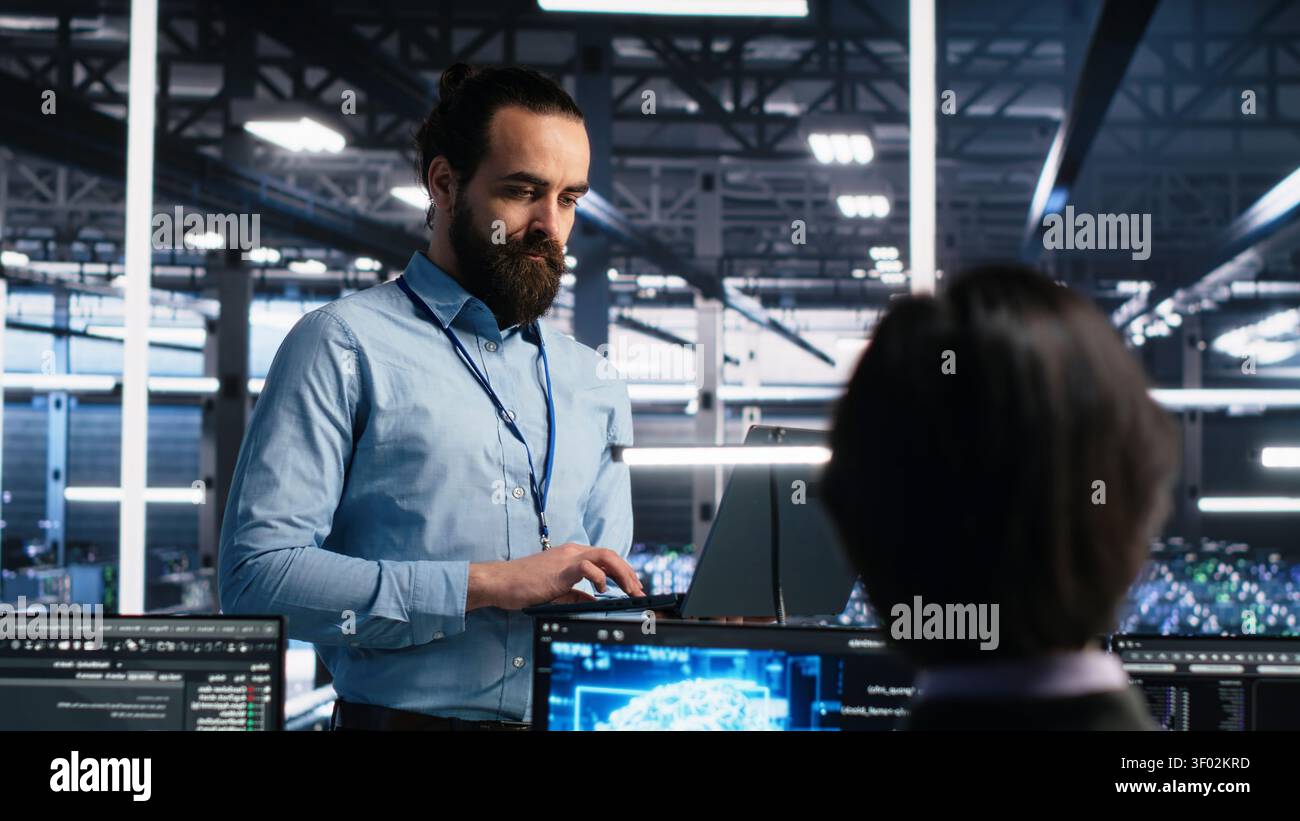 Data center manager oversees programmers reviewing AI diagnostics and machine learning systems. Stock Photo