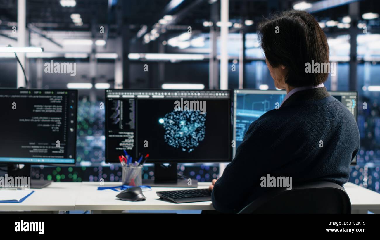 Server room system administrators working with machine learning models on computer to review data sets. Stock Photo
