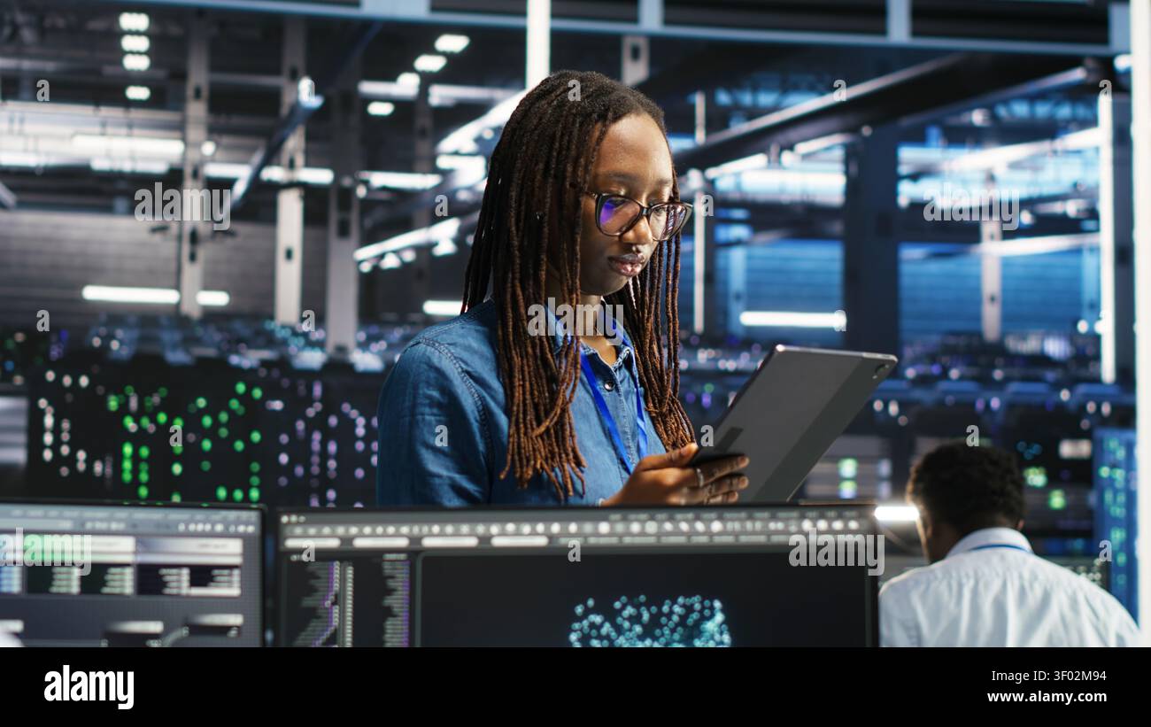 Engineer uses a computer workstation in a server farm to categorize unstructured data with node tree systems. Stock Photo