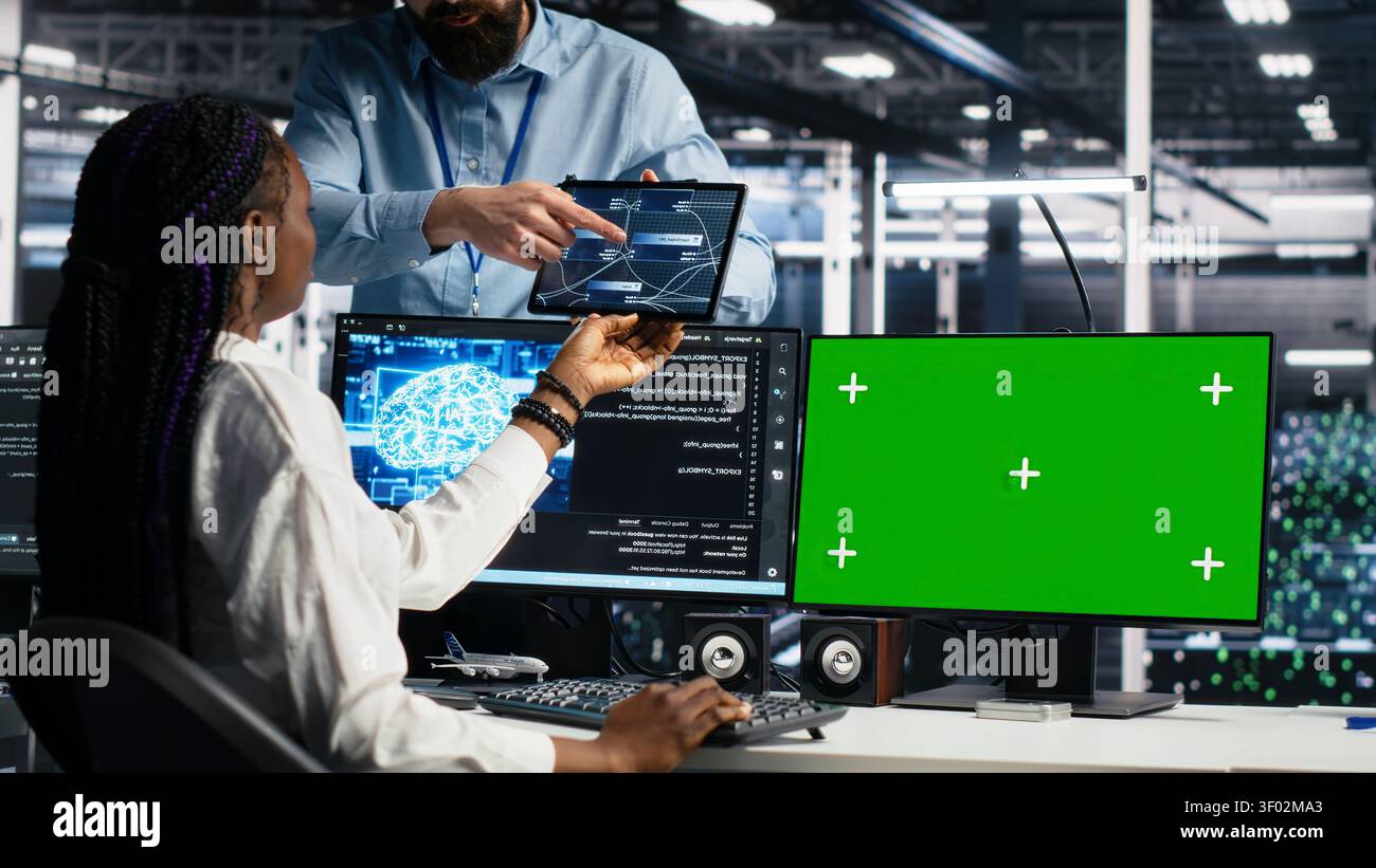 IT colleagues collaborate in a data center while reviewing AI diagnostics and infrastructure performance. Stock Photo