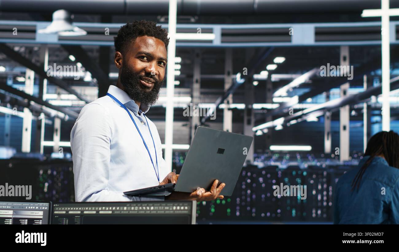 Data center administrator uses laptop node tree software to review analytics and identify equipment issues. Stock Photo