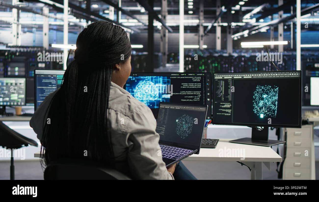 Data center IT expert working with notebook computer to apply AI technology minimizing system downtime. Stock Photo
