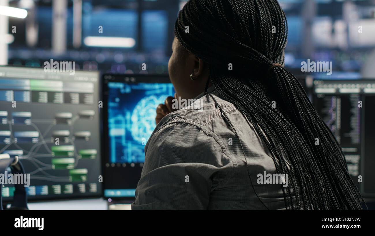 Server facility software engineer applying AI ML models to set up hardware. IT professional works on AI programming tools in server environment, optimizing system. Stock Photo